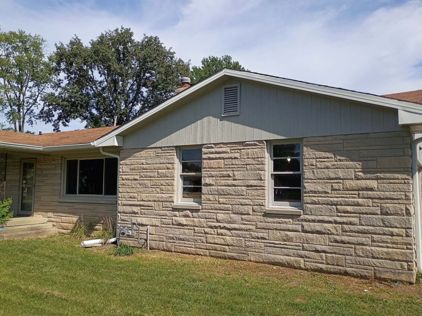 Same exterior gable end after painting, with a clean refreshed finish
